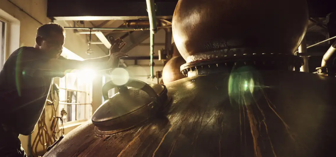 A stillman checking the copper stills